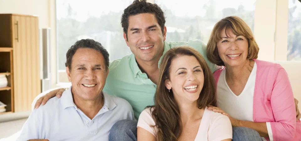 A smiling family sitting close together