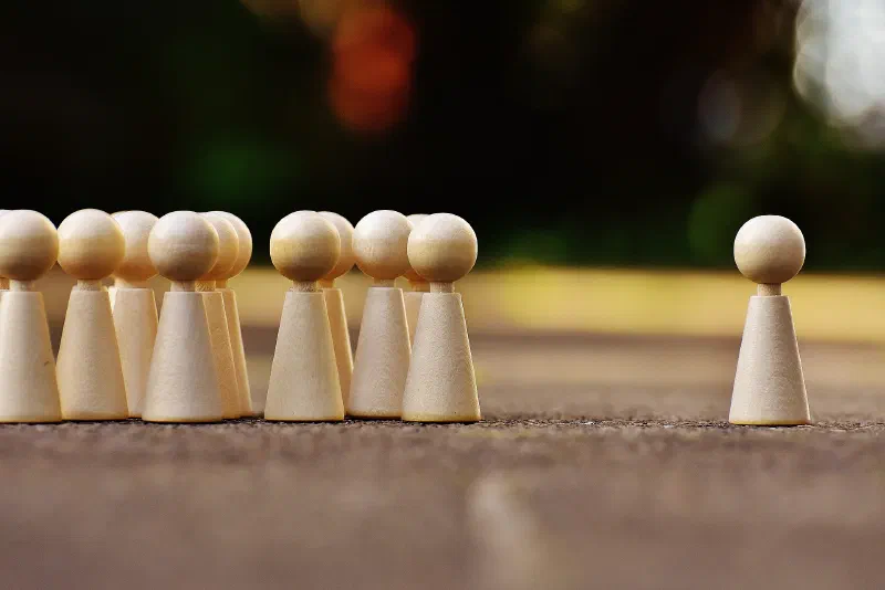 A bunch of pegs bullying one peg